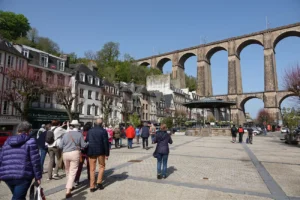 Groupe de visiteurs de l'ARSSAT sur la place des Otages à Morlaix, avec le viaduc ferroviaire et les maisons à colombages en arrière-plan