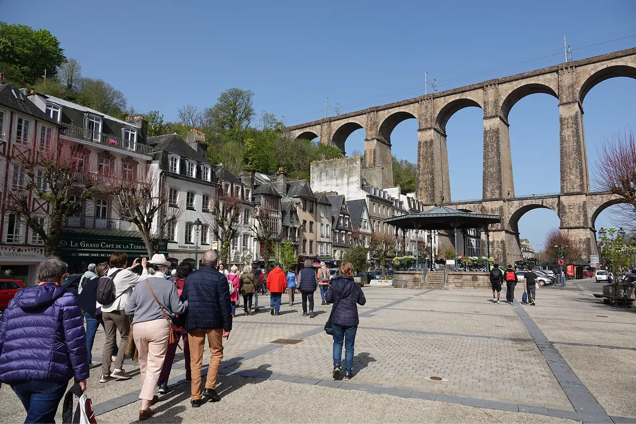 Groupe de visiteurs de l'ARSSAT sur la place des Otages à Morlaix, avec le viaduc ferroviaire et les maisons à colombages en arrière-plan