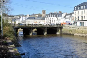 Pont sur le Léguer au cœur de Lannion avec le clocher de l'église en arrière-plan et les quais animés, Côtes-d'Armor, Bretagne