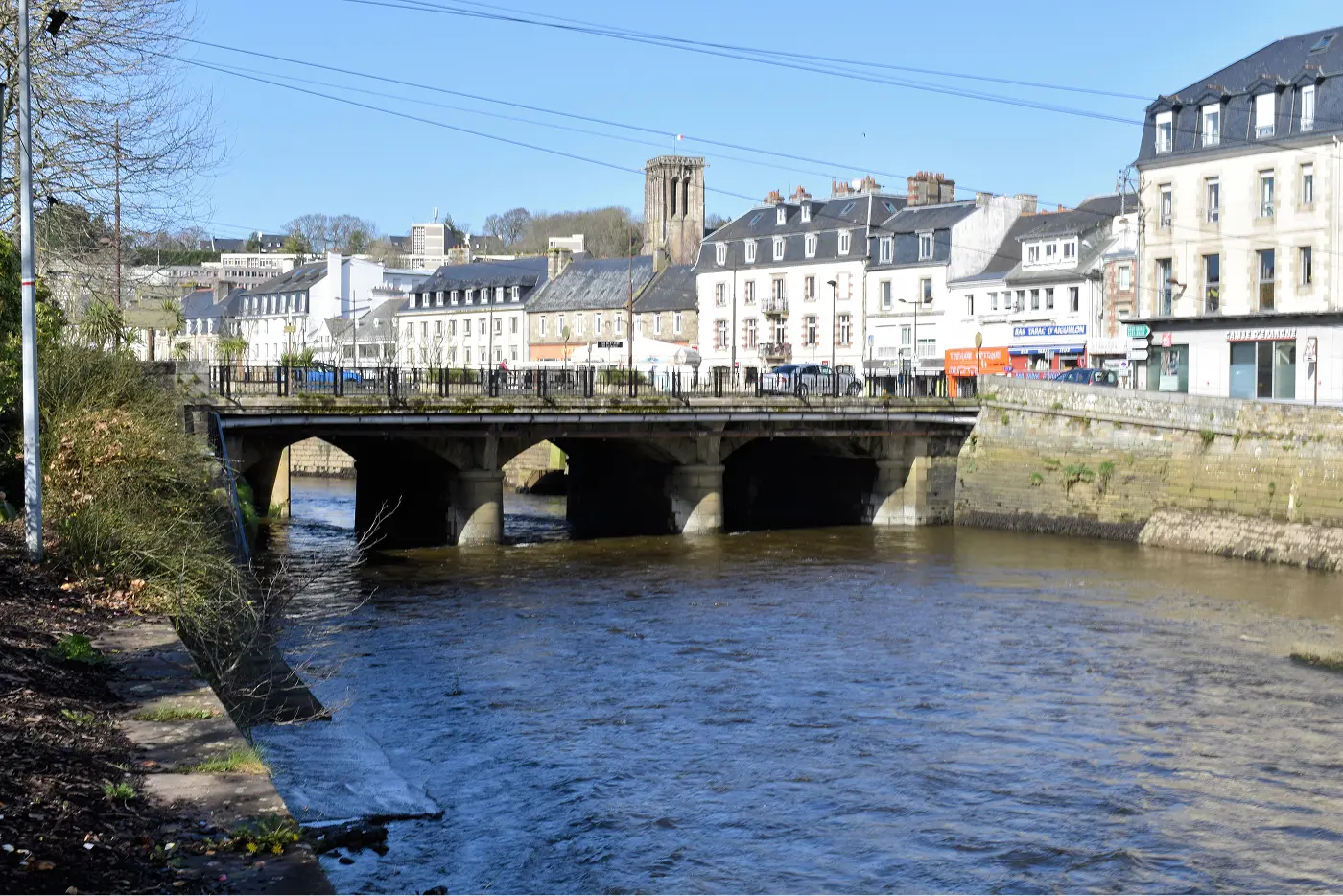 Pont sur le Léguer au cœur de Lannion avec le clocher de l'église en arrière-plan et les quais animés, Côtes-d'Armor, Bretagne