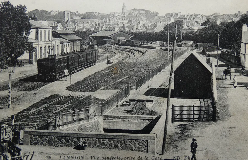 Carte postale ancienne en noir et blanc de la gare de Lannion avec locomotives à vapeur et vue panoramique sur la ville, Côtes-d'Armor, Bretagne