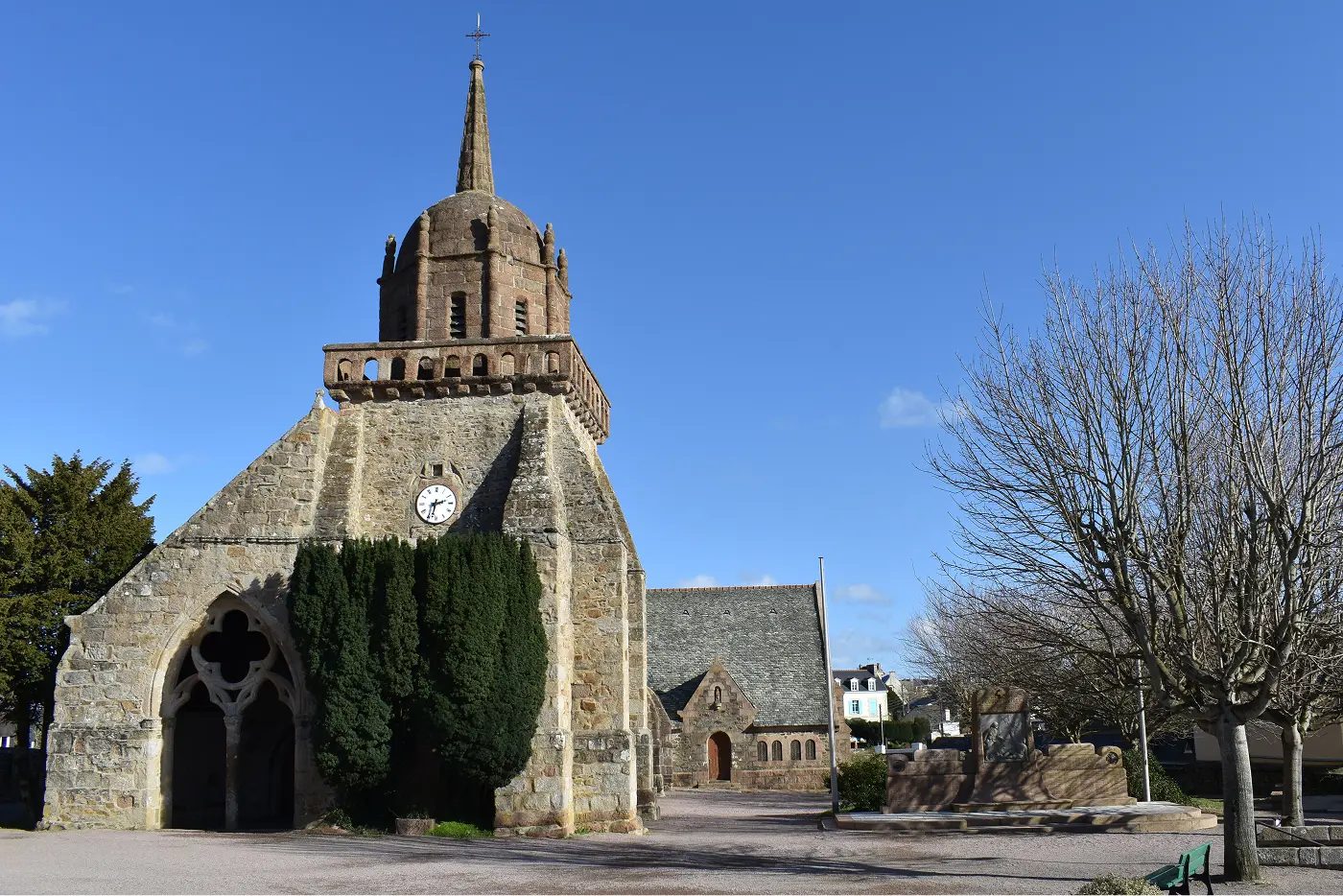 Église Saint-Jacques de Perros-Guirec, édifice en pierre de granite avec clocher octogonal et portail gothique, sous un ciel bleu, Côtes-d'Armor, Bretagne